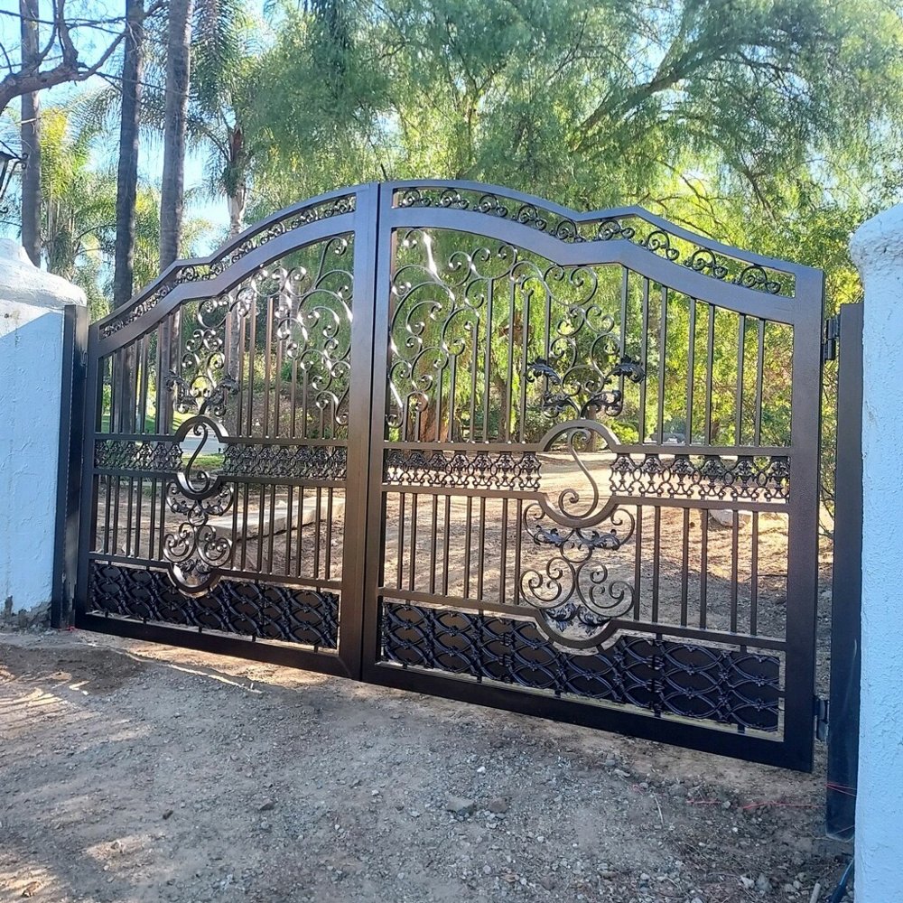 Decorative wrought iron driveway gate with scrollwork pattern